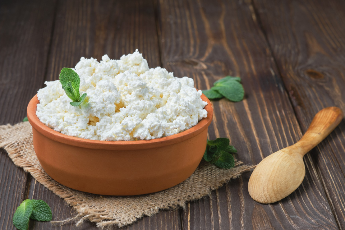 Bowl of cottage cheese with a spoon, symbolizing a healthy, protein-rich snack.