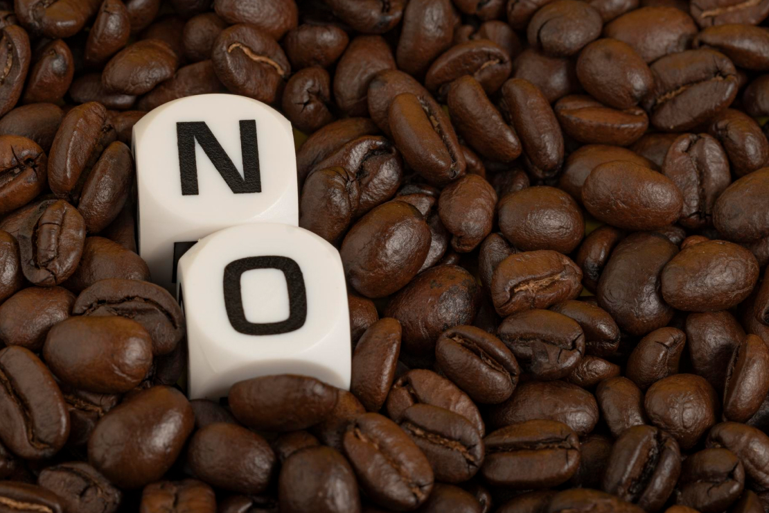 A person looking alert and productive at their desk, with a glass of water and a healthy snack instead of a coffee cup, symbolizing productivity without caffeine.